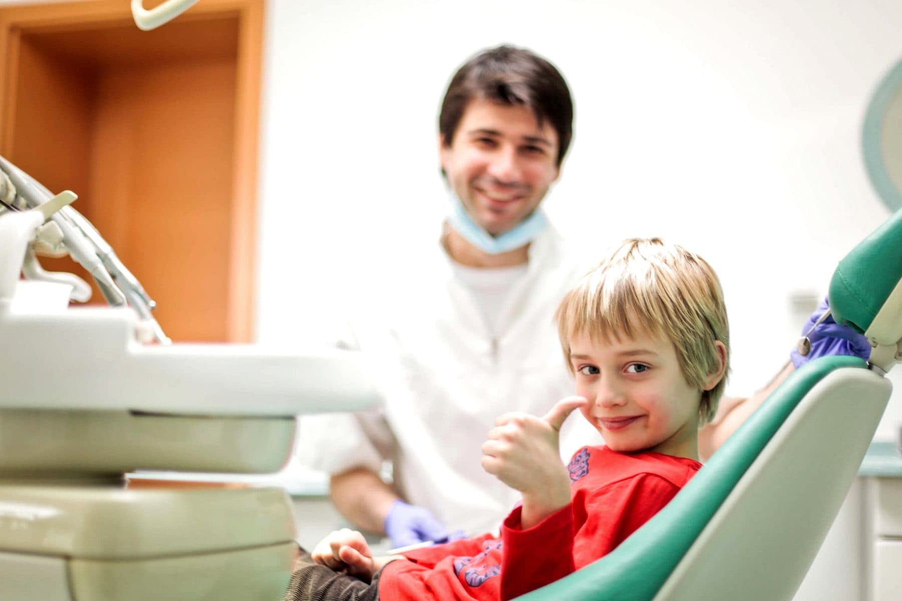 David Pintarić mit einem kleinen Patienten im Behandlungsstuhl, das Kind zeigt den Daumen nach oben